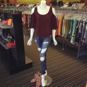 off the shoulder top and jeans with holes on a mannequin at platos closet
