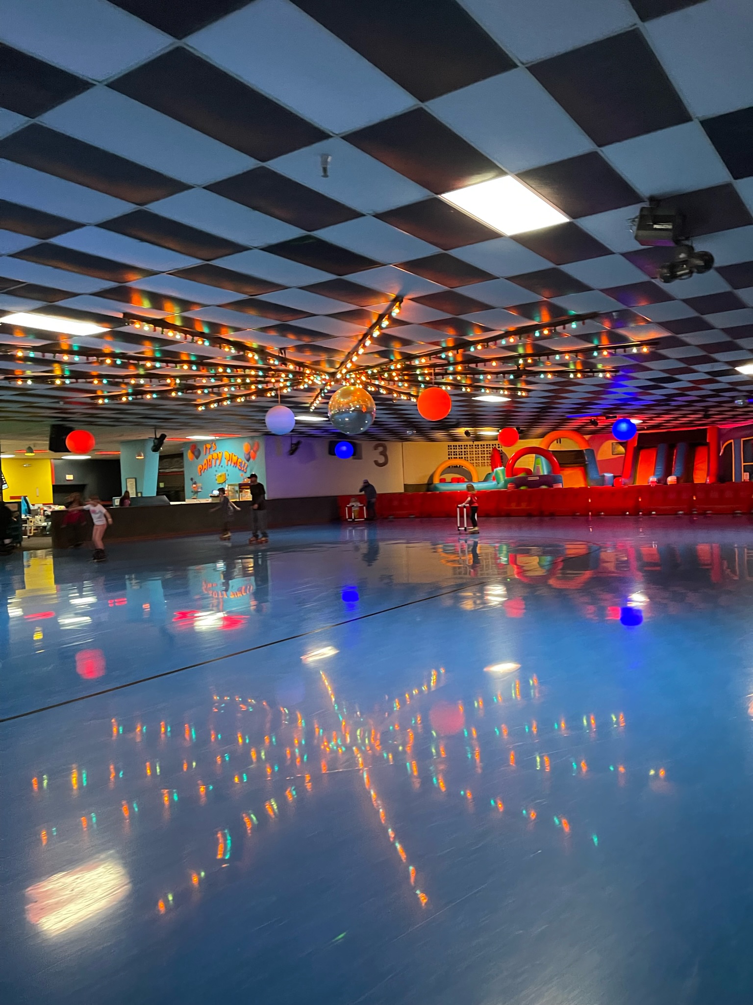lights reflecting Photo of roller rink with colorful disco lights.
